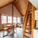 Geräumiges Wohnzimmer mit Holztreppe, Essbereich und Küchenzeile im Campingplatz Baltic Freizeit in Markgrafenheide.