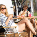 Junges Paar entspannt vor ihrem Wohnmobil, genießt Essen und Trinken auf dem Campingplatz von Baltic Freizeit.